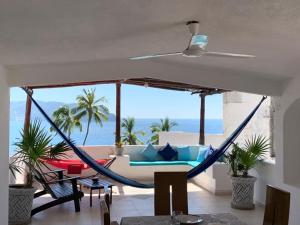 a hammock in a living room with a view of the ocean at Casa Las iguanas in Acapulco