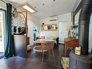 ein Wohnzimmer mit einem Holzofen im Zimmer in der Unterkunft Charmante Maison en pleine nature avec piscine in Assas
