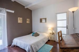 ein Schlafzimmer mit einem weißen Bett und einem Fenster in der Unterkunft Charmante Maison en pleine nature avec piscine in Assas + 18 Fotos