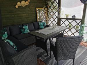 a patio with a couch and a table and chairs at Domek blisko Zamku in Malbork