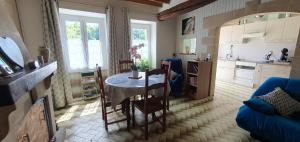 a kitchen and living room with a table and chairs at La Maison du Druide in Bonneuil-en-Valois +5 photos