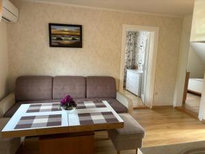 a living room with a couch and a table at Neringaholiday Apartamentai in Juodkrantė