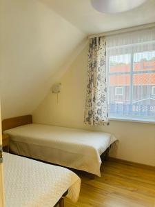 a bedroom with two beds and a window at Neringaholiday Apartamentai in Juodkrantė
