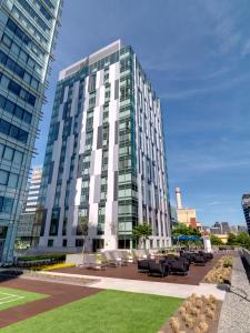 a tall building with tables and chairs in front of it at Global Luxury Suites at Kendall West in Cambridge