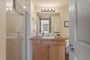 a bathroom with two sinks and a large mirror at C303 Hidden Gem with MTN andCreek View, Quiet and Private in Canmore