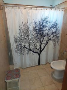 a shower curtain with a tree on it in a bathroom at Casa de Cande in Tandil +18 photos