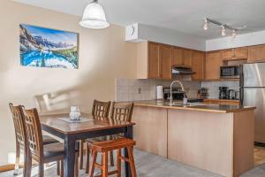 a kitchen with a table and chairs and a kitchen with a sink at C303 Hidden Gem with MTN andCreek View, Quiet and Private in Canmore
