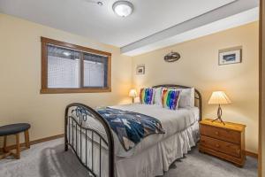 a bedroom with a bed and a table and a window at C303 Hidden Gem with MTN andCreek View, Quiet and Private in Canmore