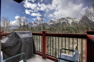 a balcony with a table and chairs and a mountain at C303 Hidden Gem with MTN andCreek View, Quiet and Private in Canmore