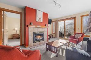 a living room with a fireplace and red walls at C303 Hidden Gem with MTN andCreek View, Quiet and Private in Canmore