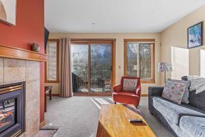 a living room with a couch and a fireplace at C303 Hidden Gem with MTN andCreek View, Quiet and Private in Canmore