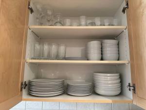 a cupboard filled with plates and bowls and glasses at C303 Hidden Gem with MTN andCreek View, Quiet and Private in Canmore