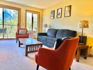 a living room with a couch and chairs and a table at C303 Hidden Gem with MTN andCreek View, Quiet and Private in Canmore