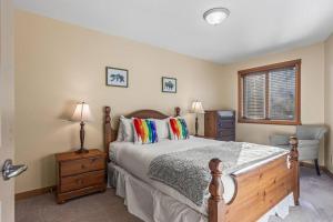 a bedroom with a bed and a chair and a window at C303 Hidden Gem with MTN andCreek View, Quiet and Private in Canmore