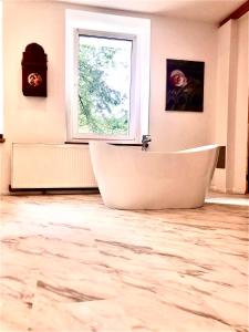 a large bathroom with a tub and a window at Slow life Karkonosze in Wojcieszyce +23 photos