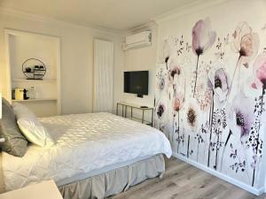 a bedroom with a bed with a flower mural on the wall at Lazy Olives in Tongeren