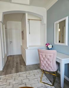 a pink chair sitting at a desk in a room at Lazy Olives in Tongeren