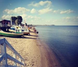 a group of people walking on a beach with boats at Angel Sea Hill Apartment in Mechelinki