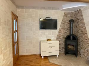 a living room with a fireplace and a tv on a wall at Neringaholiday Apartamentai in Juodkrantė