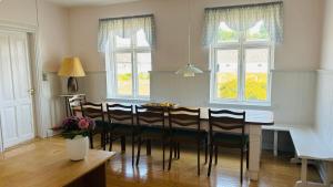 a dining room with a table and chairs and two windows at Aabenterp in Vrå +26 photos