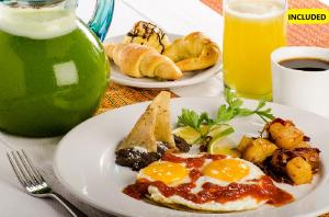 two plates of food with eggs and bread and a drink at Hacienda Uxmal Plantation & Museum in Uxmal