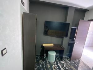 纳祖尔Hotel al andalus N7的房间里有一张桌子和一台挂在墙上的电视 更多2张照片