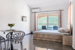a bedroom with a bed and a large window at Apartmani Divna in Neum