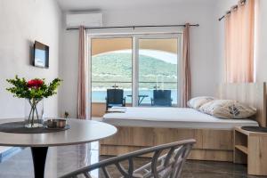 een kamer met een bed, een tafel en een raam bij Apartmani Divna in Neum