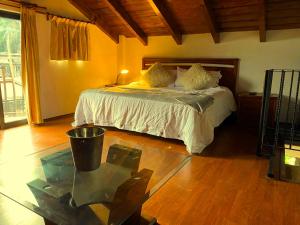 a bedroom with a bed and a glass table at Alojamiento tipo Cabaña, rodeado de Bosque in Mexico City