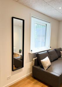 a living room with a couch and a mirror at Lovely Billund Apartment by KIRIJA in Billund