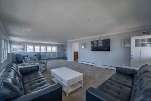 a large living room with couches and a tv at OCHG Lankford Oceanfront Penthouse in Ocean City