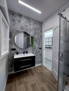 un baño con lavabo y espejo en El nido de la gaviota, en Moaña