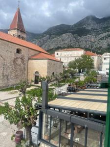 a view of a city with a church and mountains at Old town Pjaca Makarska in Makarska