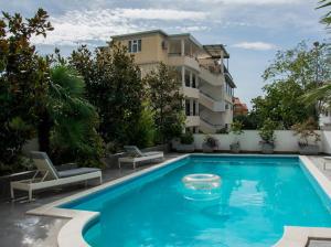 a large blue swimming pool in front of a building at Lux Villa Ivan Budva in Budva