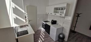 a small white kitchen with a stove and a sink at Central Apartment Krefeld in Krefeld