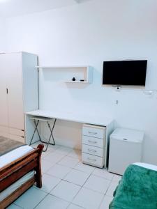 a bedroom with a desk and a tv on a wall at Pousada Morada Bonfim in Olinda +16 photos