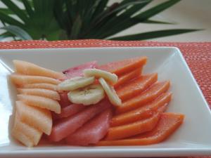 a plate of fruit and vegetables on a table at Hacienda Real del Caribe Hotel in Playa del Carmen
