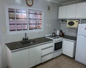 a kitchen with a sink and a stove top oven at Agus-Marti in Nueve de Julio