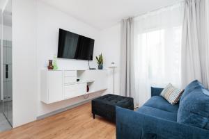 a living room with a blue couch and a tv at City of the Kings - Riverside B22 in Kraków
