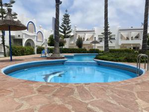 a swimming pool with a dolphin in the middle at calm and secure residence with pool in Sidi Bouzid