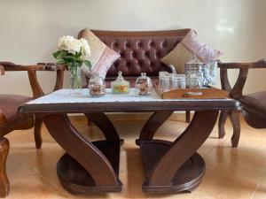 a wooden coffee table with a vase of flowers on it at calm and secure residence with pool in Sidi Bouzid