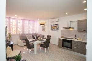 a kitchen and a living room with a table and chairs at Lux apartment Draga with balkony in Split