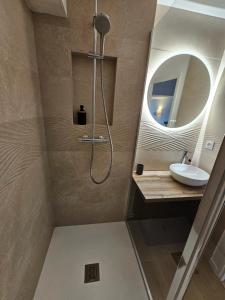 a bathroom with a shower with a sink and a mirror at Ocea Marina appartement vue mer refait à neuf avec parking privatif in Deauville +33 photos