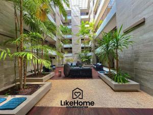 a lobby of a building with palm trees in it at Eco Summer Tambaú, LikeHome in Tambaú