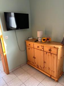 a television on a wall above a wooden dresser at Ferienwohnung Burg Katz in Lahnstein
