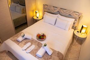 a bedroom with a large white bed with a bowl of fruit at Ancient port house in Mytilini