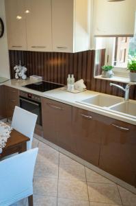 a kitchen with brown cabinets and a sink and a table at Ancient port house in Mytilini +22 photos