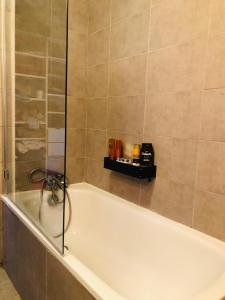 a bathroom with a bath tub with a shower at Appartement très haut avec Piscine, sauna, salle de sport et solarium in Paris
