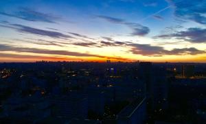 a sunset view of a city with buildings at Appartement très haut avec Piscine, sauna, salle de sport et solarium in Paris +74 photos
