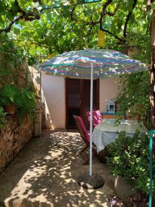 a table and chairs under an umbrella in a yard at Apartment Marinetto in Stari Grad